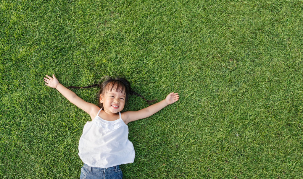 Asian,Little,Girl,Smile,And,Lay,On,Grass